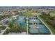 Aerial view of the community tennis courts showcasing green courts, sun shades, and lush landscaping at 1004 Regal Manor Way, Sun City Center, FL 33573