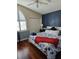 Nautical-themed bedroom with hardwood floors, a large window, and comfortable furnishings at 1050 Starkey Rd # 2503, Largo, FL 33771