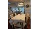 Dining area with a long white-clothed table, six chairs, and a view of the living area at 1050 Starkey Rd # 2503, Largo, FL 33771