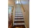 Wooden staircase featuring painted white risers, wooden treads, and a decorative wooden banister at 1050 Starkey Rd # 2503, Largo, FL 33771