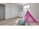 Bedroom featuring light wood floors, a closet, and a pink teepee for  at 11005 Tyler Dr, Port Richey, FL 34668