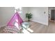 Bright bedroom featuring light wood floors and a pink teepee for  at 11005 Tyler Dr, Port Richey, FL 34668