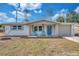 Charming, updated single-story home featuring a bright blue front door, fresh paint, and a well-maintained front lawn at 11005 Tyler Dr, Port Richey, FL 34668