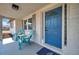 Charming front porch with comfortable seating and a vibrant blue door offering a welcoming entrance at 11005 Tyler Dr, Port Richey, FL 34668