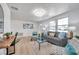 Bright living room with gray sofa, patterned chairs, natural light, and wood-look floors at 11005 Tyler Dr, Port Richey, FL 34668