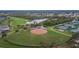 The community's aerial view showcases the baseball field, tennis courts, and scenic landscaping at 1228 Caloosa Creek Ct, Sun City Center, FL 33573