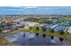 An aerial view displays the community buildings near the lake with a fountain and several tennis courts at 1228 Caloosa Creek Ct, Sun City Center, FL 33573