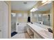 Bright bathroom with double sink, tub, and walk-in shower, providing a relaxing experience at 1228 Caloosa Creek Ct, Sun City Center, FL 33573