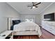 Bedroom with ceiling fan, wood floors, white furniture, and natural light at 1228 Caloosa Creek Ct, Sun City Center, FL 33573