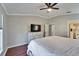 Bedroom featuring ceiling fan, white dresser with TV, and wood floors at 1228 Caloosa Creek Ct, Sun City Center, FL 33573