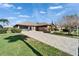 Charming single-story home with brick driveway, well-manicured landscaping, and a welcoming screened in porch at 1228 Caloosa Creek Ct, Sun City Center, FL 33573