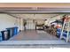 Garage interior with door open showcasing organized storage, epoxy floor and ample space at 1228 Caloosa Creek Ct, Sun City Center, FL 33573