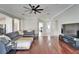 Spacious living room with hardwood floors, a ceiling fan, open layout, and stylish furnishings at 1228 Caloosa Creek Ct, Sun City Center, FL 33573