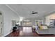 Spacious living room with hardwood floors, a ceiling fan, and large windows offering plenty of natural light at 1228 Caloosa Creek Ct, Sun City Center, FL 33573