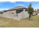 Fenced backyard with brick patio, screened-in porch, and a lawn with trees under a sunny sky at 13351 Crest Lake Dr, Hudson, FL 34669