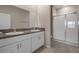 Bathroom featuring double vanity with granite countertop, tiled shower with glass door, and tiled floors at 13351 Crest Lake Dr, Hudson, FL 34669