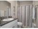 Bathroom featuring granite countertop, undermount sink, a decorative mirror, and a shower with striped curtain at 13351 Crest Lake Dr, Hudson, FL 34669