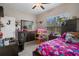 Bedroom with ceiling fan, window with blinds, bed with colorful patterned bedding, and dark wood furniture at 13351 Crest Lake Dr, Hudson, FL 34669