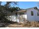 Side view of the white, one-story home showing a sliding glass door and several windows at 13386 Taylor St, Brooksville, FL 34613