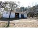 Exterior view of detached garage with two doors, one open, and lawn debris at 13386 Taylor St, Brooksville, FL 34613