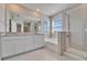 Luxurious main bathroom featuring double vanity, soaking tub, and glass-enclosed shower at 16725 Barnwood Pl, Bradenton, FL 34211