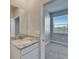 Bathroom featuring granite countertop vanity and a view to the bedroom with a window at 16725 Barnwood Pl, Bradenton, FL 34211