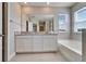 Bright bathroom with double vanity, a soaking tub, and glass-enclosed shower at 16725 Barnwood Pl, Bradenton, FL 34211