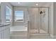 Bright bathroom with a soaking tub under a window, and a glass enclosed shower with rainfall shower head at 16725 Barnwood Pl, Bradenton, FL 34211