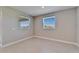 A bedroom with tile floors and two windows, with neutral paint at 16725 Barnwood Pl, Bradenton, FL 34211