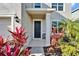 Close-up of the front entrance with red foliage, a sleek black door, and decorative stone accents at 16725 Barnwood Pl, Bradenton, FL 34211