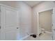 Hallway with white tile flooring and views into the bathroom and entryway at 16725 Barnwood Pl, Bradenton, FL 34211