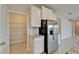 Bright kitchen featuring stainless steel refrigerator, white cabinets, granite counters, and walk-in pantry at 16725 Barnwood Pl, Bradenton, FL 34211