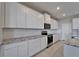 Modern kitchen featuring white cabinets, granite countertops, and stainless steel appliances at 16725 Barnwood Pl, Bradenton, FL 34211