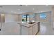 Kitchen island with sink and granite countertops, with large sliding glass doors to the outside at 16725 Barnwood Pl, Bradenton, FL 34211