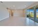 Open floor plan living room featuring tile flooring and large glass sliding doors at 16725 Barnwood Pl, Bradenton, FL 34211