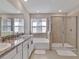 A spacious bathroom with a large glass shower, soaking tub, and granite countertop vanity at 16733 Glacier Bay Loop, Wimauma, FL 33598