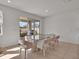 Dining room with modern glass table, seating for eight, and sliding door to the backyard at 16733 Glacier Bay Loop, Wimauma, FL 33598