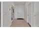 Bright hallway with neutral tile flooring, white walls, and doors leading to various rooms at 16733 Glacier Bay Loop, Wimauma, FL 33598