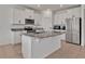 Kitchen featuring a large island, granite countertops, stainless steel appliances, and white cabinets at 16733 Glacier Bay Loop, Wimauma, FL 33598