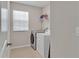 This laundry room offers tile floors, washer, dryer, and shelving at 16733 Glacier Bay Loop, Wimauma, FL 33598