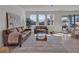 Bright living room with neutral furniture, contemporary rug, and sliding doors to backyard and dining area at 16733 Glacier Bay Loop, Wimauma, FL 33598