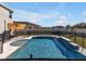 Backyard pool and spa area with fence, deck, umbrella, and outdoor seating, perfect for relaxation at 16733 Glacier Bay Loop, Wimauma, FL 33598