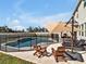 An outdoor pool featuring an umbrella, lounge chairs, and clear blue water at 16733 Glacier Bay Loop, Wimauma, FL 33598