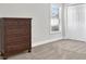 Well-lit bedroom with wood dresser and neutral carpeting at 17112 Downs Dr, Odessa, FL 33556