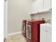 Bright laundry room with red appliances and white cabinets at 17112 Downs Dr, Odessa, FL 33556