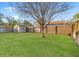 Fenced backyard with green grass and a storage shed for added convenience and space to store belongings at 1920 E Idlewild Ave, Tampa, FL 33610