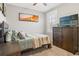 Cozy bedroom features neutral walls, a comfortable bed, and a dark wood dresser with a wall-mounted television at 1920 E Idlewild Ave, Tampa, FL 33610