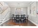 Elegant dining room with dark wood floors, stairs, and natural light from bright windows at 1920 E Idlewild Ave, Tampa, FL 33610