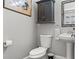 Modern powder room featuring pedestal sink, decorative mirror and cabinet, and neutral wall color at 1920 E Idlewild Ave, Tampa, FL 33610