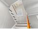 Bright stairway featuring white risers, hardwood treads, and modern chandelier at 1920 E Idlewild Ave, Tampa, FL 33610